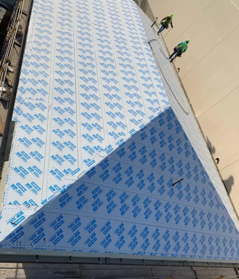 Professional roofers installing underlayment on a metal roof in Evesham